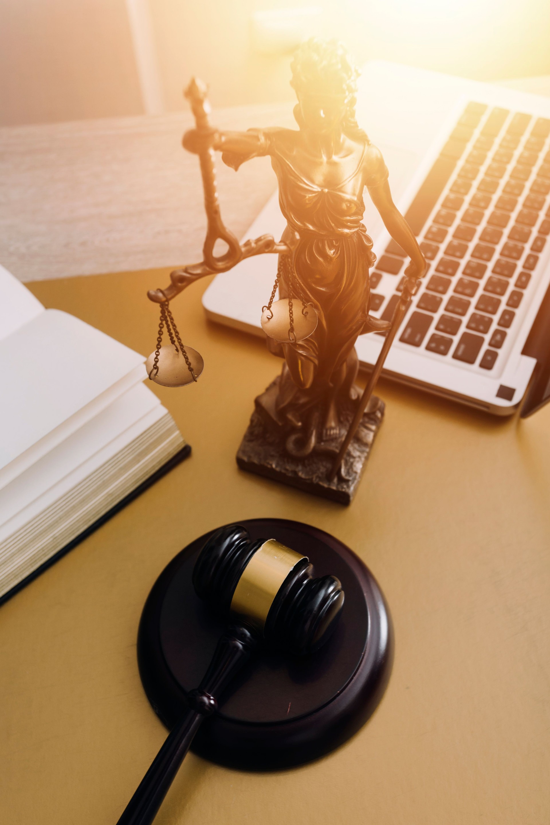 Justice and law concept.Male judge in a courtroom with the gavel, working with, computer and docking keyboard, eyeglasses, on table in morning light