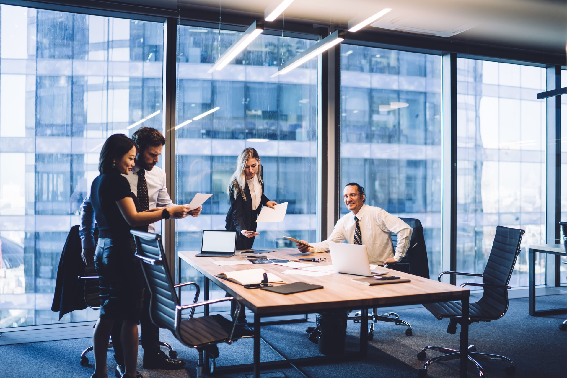 Group of diverse executive managers doing paperwork at meeting